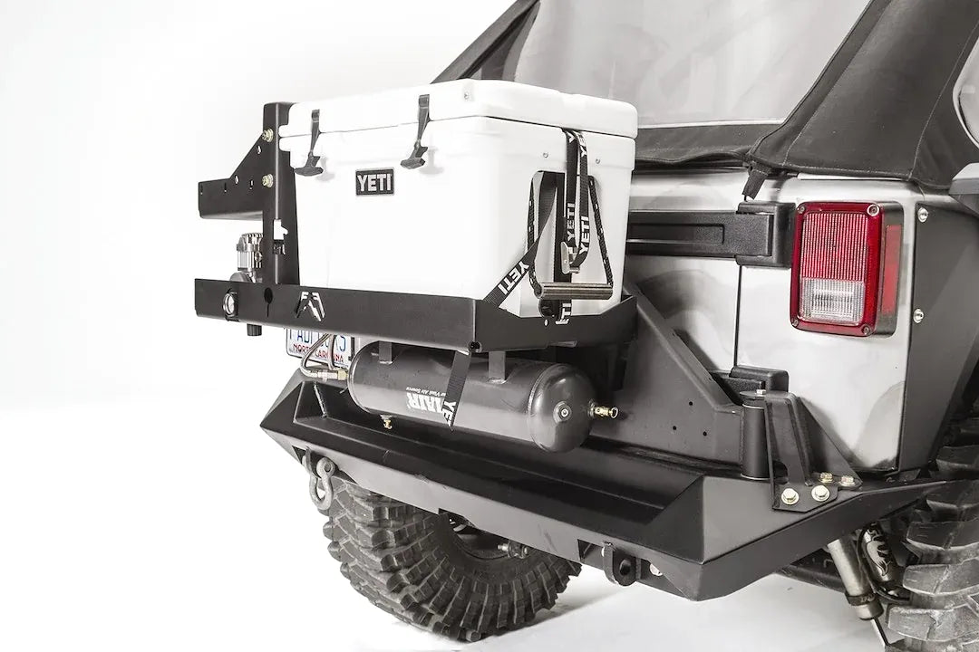Close-up of the Fab Fours cooler mount on a Jeep Wrangler JK, passenger side, showing the Yeti Tundra 35 secured with straps above the Viair air tank