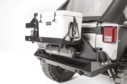 Close-up of the Fab Fours cooler mount on a Jeep Wrangler JK, passenger side, showing the Yeti Tundra 35 secured with straps above the Viair air tank