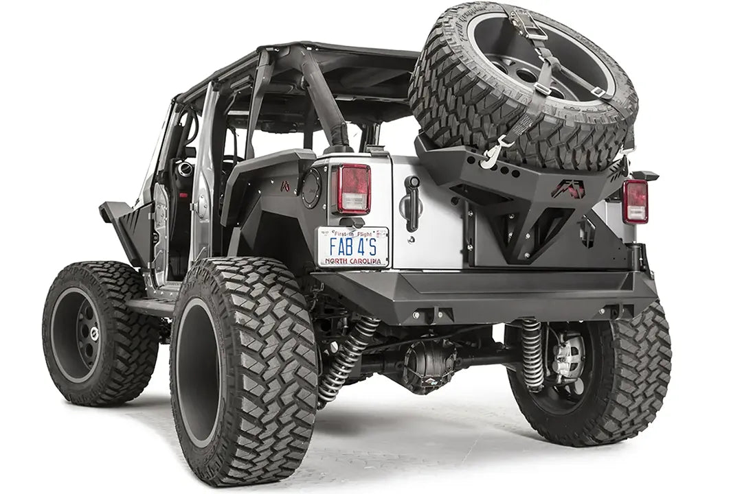 Fab Fours Slant Back Tire Carrier on a Jeep Wrangler JK, rear driver-side view, with the strapped spare mounted over the tailgate and rear bumper