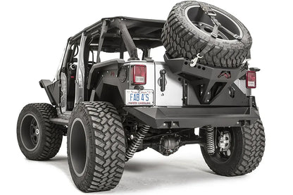 Fab Fours Slant Back Tire Carrier on a Jeep Wrangler JK, rear driver-side view, with the strapped spare mounted over the tailgate and rear bumper