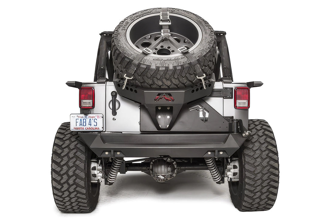 Fab Fours Slant Back Tire Carrier on a Jeep Wrangler JK, rear view, holding an oversized spare with ratchet straps above the rear bumper