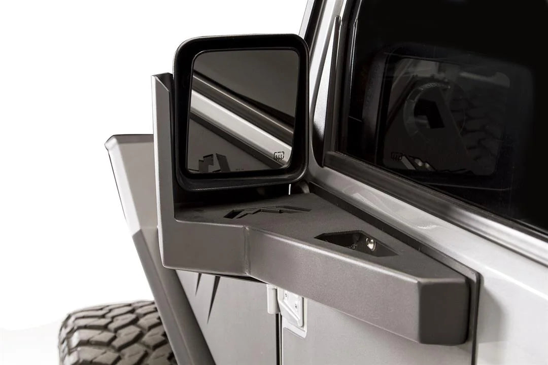 Close-up of the Fab Fours door skin mirror guard on a Jeep Wrangler JK, driver side, with the mirror set in the formed steel bracket on the door skin