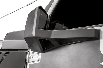 Back view of the Fab Fours door skin mirror guard on a Jeep Wrangler JK, showing the boxed steel arm and mounting bracket bolted to the door skin