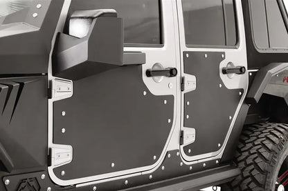Close-up of Fab Fours door skins on a silver Jeep Wrangler JK, driver side, showing the matte black steel panels bolted around the door handles and hinges with stainless hardware