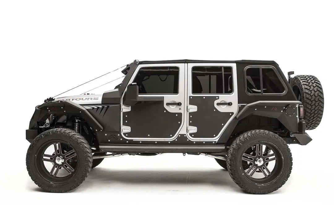 Fab Fours door skins on a lifted silver four-door Jeep Wrangler JK Unlimited, driver-side profile, showing black steel panels bolted to the front and rear doors with matching Fab Fours armor