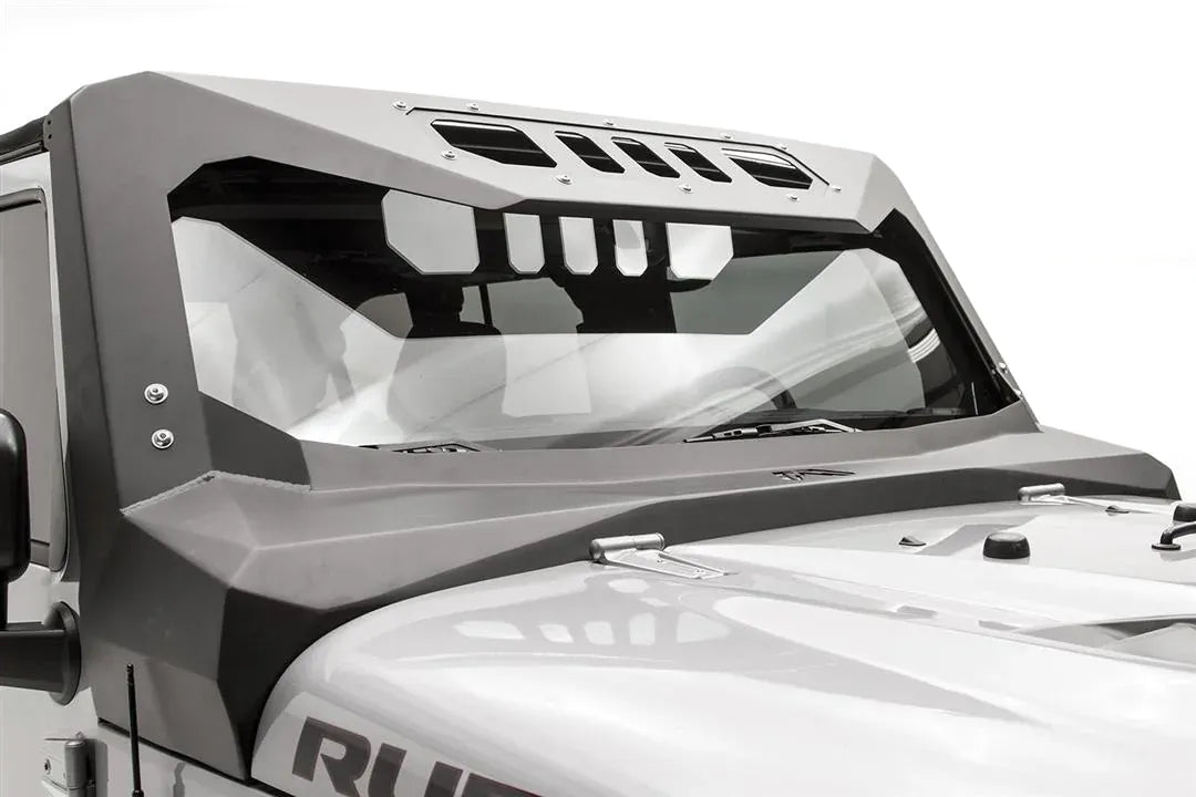 Close-up of the Fab Fours ViCowl on a silver Jeep Wrangler JK, passenger side, showing the angular steel cowl, bolted A-pillar cover and slotted roof visor