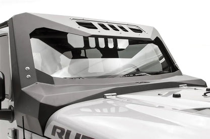 Close-up of the Fab Fours ViCowl on a silver Jeep Wrangler JK, passenger side, showing the angular steel cowl, bolted A-pillar cover and slotted roof visor