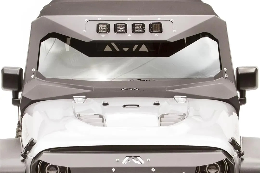 Close-up of the Fab Fours ViCowl Light Insert on a Jeep Wrangler JK, front view, showing four cube lights bolted into the insert plate at the top of the windshield cowl