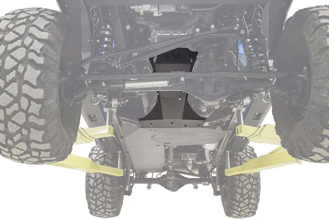 Fab Fours transmission and oil pan skid plate on a Jeep Wrangler JK, underside view on a lift, with the black steel skid plate highlighted against the faded-out frame, axle and suspension