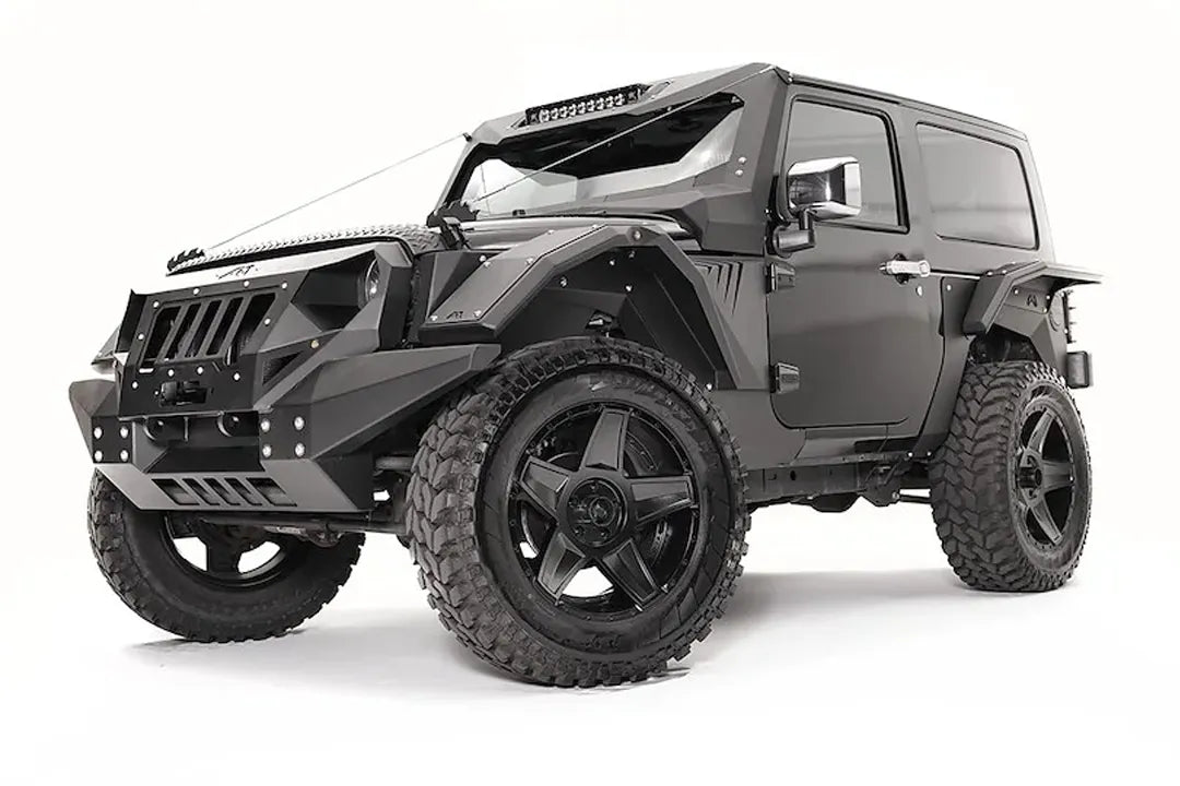 Fab Fours rear fender base on a dark gray 2-door Jeep Wrangler JK, driver-side front three-quarter view, showing the riveted fender armor and wheel clearance