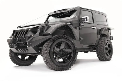 Fab Fours rear fender base on a dark gray 2-door Jeep Wrangler JK, driver-side front three-quarter view, showing the riveted fender armor and wheel clearance