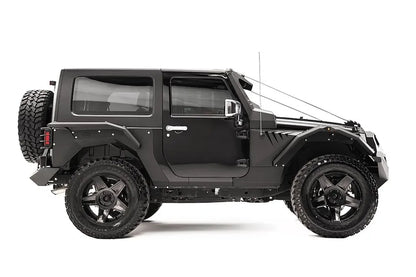 Fab Fours rear fender base on a dark gray 2-door Jeep Wrangler JK, passenger-side profile view, showing the riveted rear fender panel and rear wheel clearance