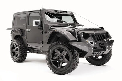 Fab Fours rear fender base on a dark gray 2-door Jeep Wrangler JK, passenger-side front three-quarter view, showing the riveted fender armor and wheel clearance