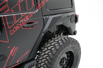 Close-up of Fab Fours rear steel fender with Fab Fours logo around the fuel door on the driver side of a black Jeep Wrangler JL with red Fab Fours graphics