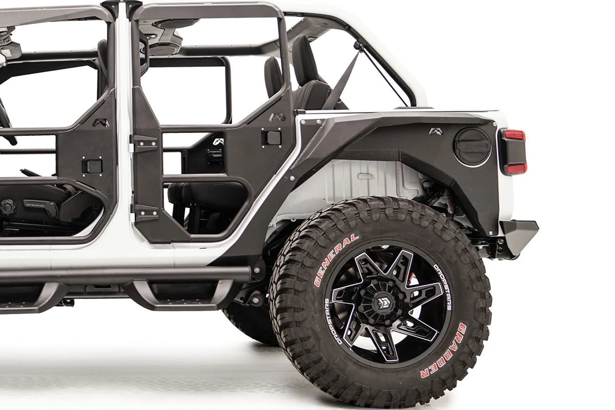 Fab Fours rear steel fender with Fab Fours logo on a lifted white Jeep Wrangler JL with tube doors, driver-side view of the rear wheel