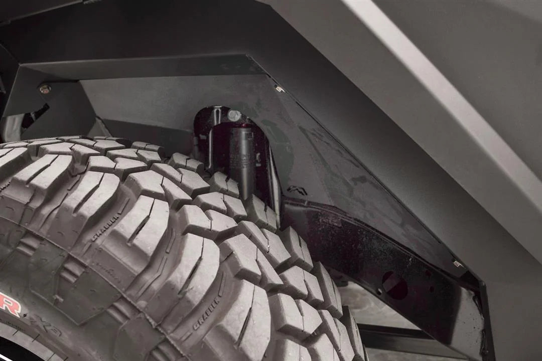 Close-up of Fab Fours front inner fender liner with Fab Fours logo cutout around the shock tower of a Jeep Wrangler JL