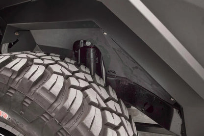 Close-up of Fab Fours front inner fender liner with Fab Fours logo cutout around the shock tower of a Jeep Wrangler JL
