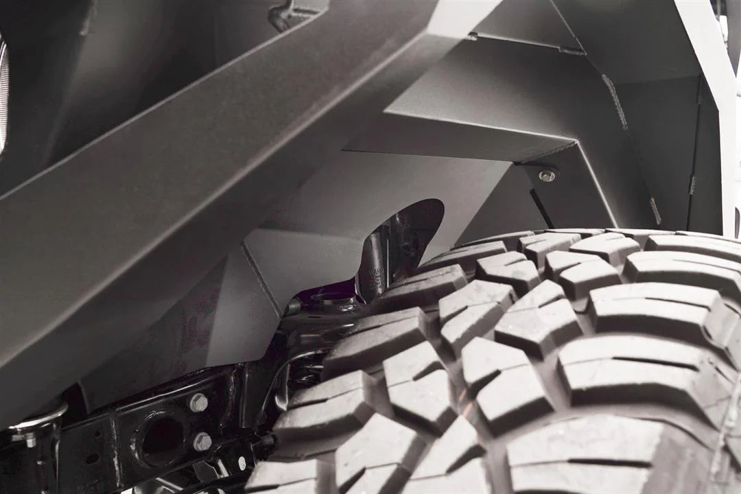 Close-up of Fab Fours front inner fender liner above the tire and shock on a Jeep Wrangler JL