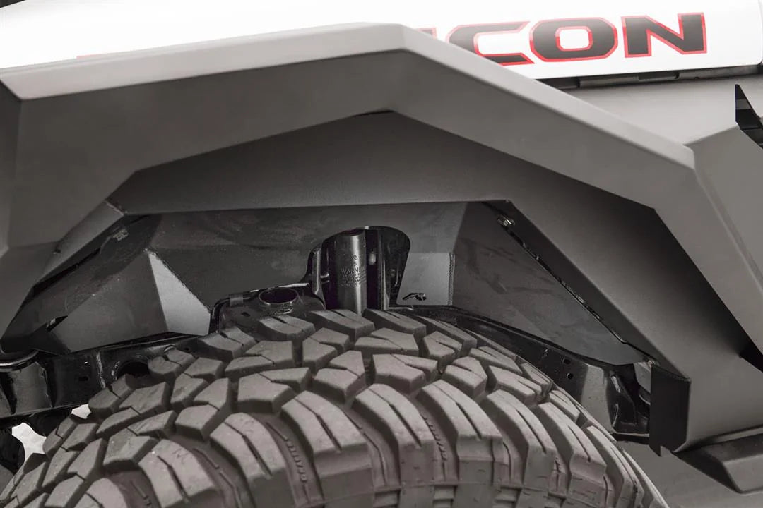 Fab Fours front inner fender liner with Fab Fours logo in the front wheel well of a Jeep Wrangler JL Rubicon, showing clearance around the shock