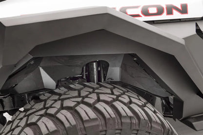 Fab Fours front inner fender liner with Fab Fours logo in the front wheel well of a Jeep Wrangler JL Rubicon, showing clearance around the shock