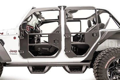 Fab Fours full tube doors on a lifted white Jeep Wrangler JL Rubicon Unlimited, front driver-side view, showing black tubular front and rear doors with steel lower panels, with a Fab Fours front bumper and grille