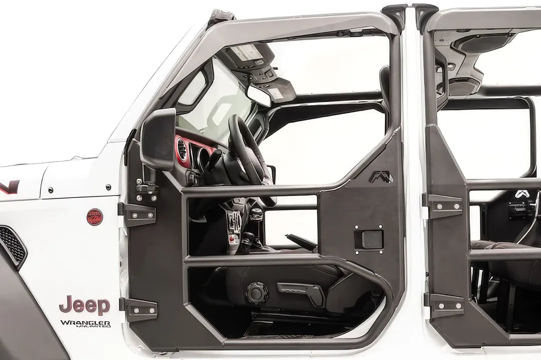 Fab Fours full tube front door on a white Jeep Wrangler JL Unlimited, driver-side close-up, showing the tubular frame with mirror mount, steel lower panel, paddle latch and Fab Fours logo