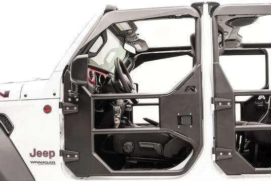 Fab Fours full tube front door on a white Jeep Wrangler JL Unlimited, driver-side close-up, showing the tubular frame with mirror mount, steel lower panel, paddle latch and Fab Fours logo
