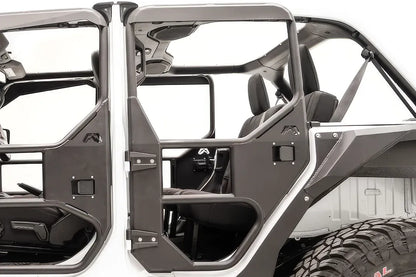 Fab Fours full rear tube door on a white Jeep Wrangler JL Unlimited, driver-side close-up, showing the tubular frame, steel lower panel, paddle latch and Fab Fours logo