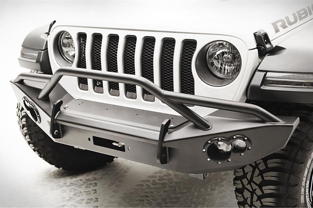 Fab Fours Lifestyle winch bumper on a white Jeep Wrangler JL, close-up of the front bumper, showing the winch plate, tube hoop and integrated light pods