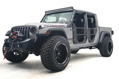 Fab Fours Stubby bumper on a gray Jeep Gladiator JT, driver-side front three-quarter view, showing the compact bumper, exposed winch and tube doors