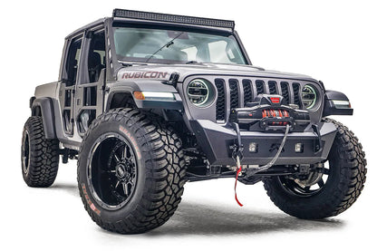 Fab Fours Stubby bumper on a gray Jeep Gladiator JT, passenger-side front three-quarter view, showing the compact bumper, winch with red hook and cube light openings