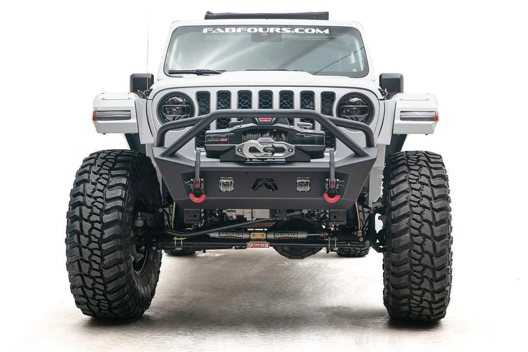 Fab Fours Stubby bumper with pre-runner guard on a white Jeep Wrangler JL, straight-on front view, showing the tube hoop, centered winch and red D-ring shackles