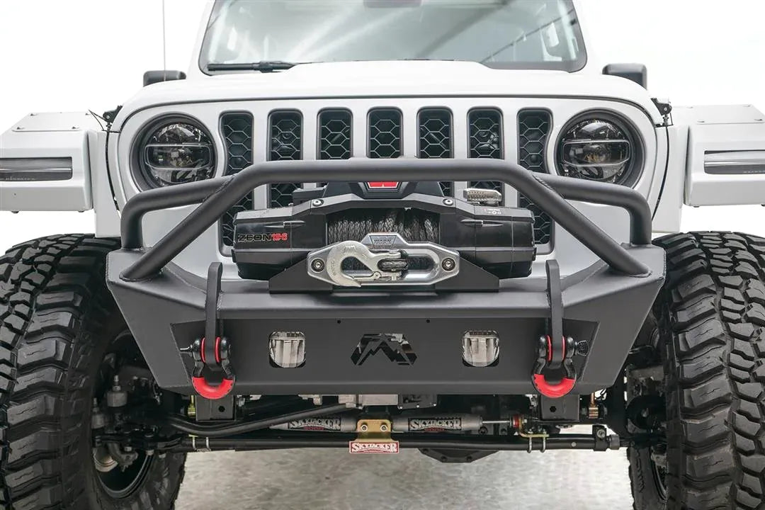 Fab Fours Stubby bumper with pre-runner guard on a white Jeep Wrangler JL, straight-on front close view, showing the tube hoop, winch, light cutouts and red D-ring shackles