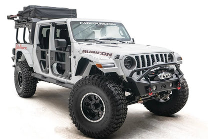 Fab Fours Stubby bumper with pre-runner guard on a white Jeep Wrangler JL, passenger-side front three-quarter view, showing the tube hoop, winch and red D-ring shackles