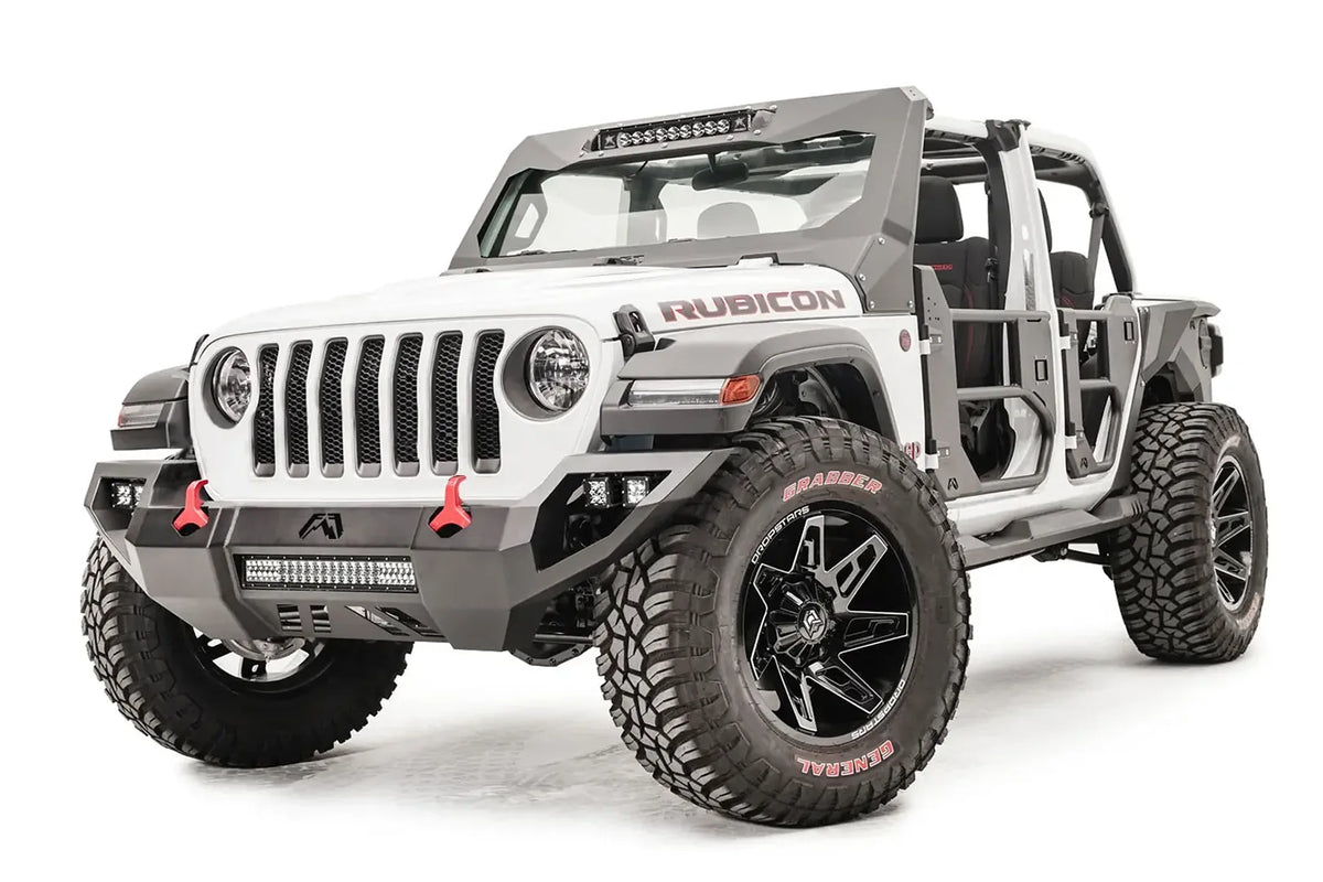 Fab Fours Vengeance front bumper on a white Jeep Wrangler JL, driver-side front three-quarter view, showing the angular bumper, integrated LED light bar and red tow hooks
