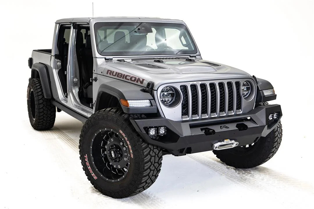 Fab Fours Matrix front bumper on a silver Jeep Gladiator JT, passenger-side front three-quarter view, showing the full-width bumper, winch fairlead and cube light pods