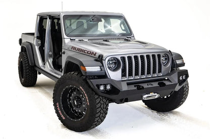 Fab Fours Matrix front bumper on a silver Jeep Gladiator JT, passenger-side front three-quarter view, showing the full-width bumper, winch fairlead and cube light pods