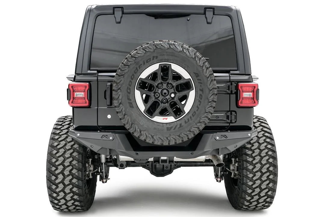 Fab Fours heavy-duty rear bumper on a lifted black Jeep Wrangler JL, straight rear view, with tailgate-mounted spare tire and hitch receiver