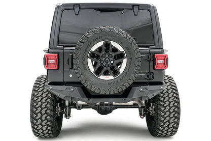 Fab Fours heavy-duty rear bumper on a lifted black Jeep Wrangler JL, straight rear view, with tailgate-mounted spare tire and hitch receiver