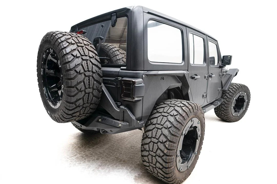 Fab Fours Off-The-Door Tire Carrier on a gray Jeep Wrangler JL Unlimited, rear passenger-side view