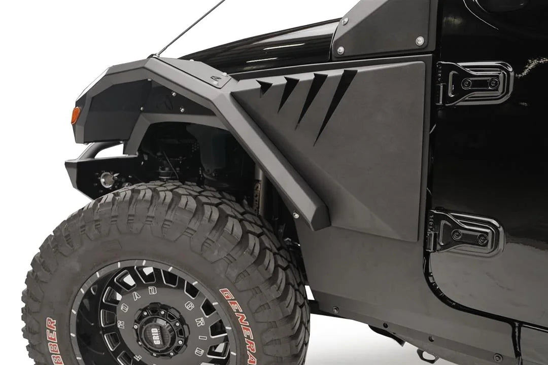 Close-up of Fab Fours front fender flare and gill vent panel on the driver side of a black Jeep Wrangler JL, with off-road tire