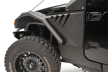 Close-up of Fab Fours front fender flare and gill vent panel on the driver side of a black Jeep Wrangler JL, with off-road tire