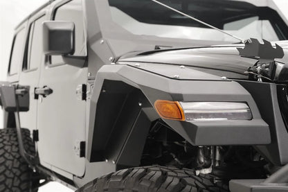 Close-up of Fab Fours front fender flare with LED turn signal on the passenger side of a gray Jeep Wrangler JL