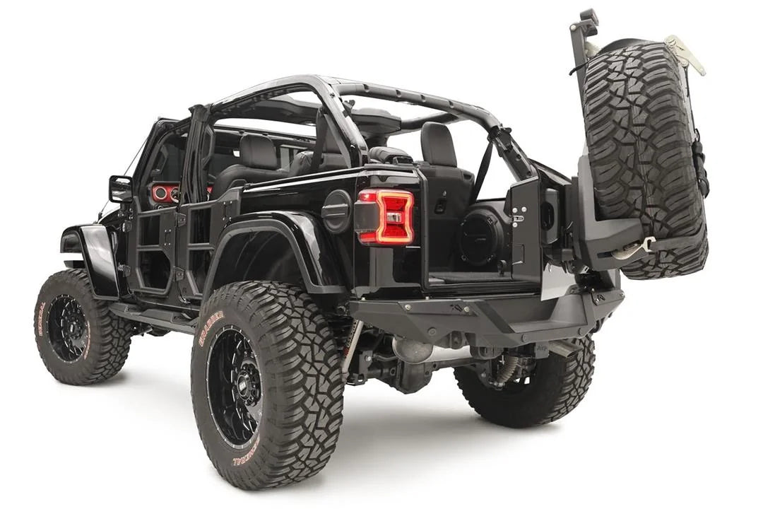 Fab Fours spare tire carrier on a black Jeep Wrangler JL, rear driver-side view, swung open to show tailgate access