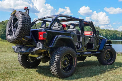 Fab Fours spare tire carrier on a black Jeep Wrangler JL outdoors, rear passenger-side view