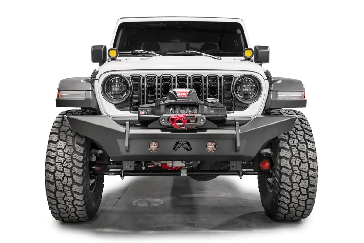 Fab Fours Premium front Lifestyle bumper on a white Jeep Wrangler JL, straight-on front view, showing the full-width bumper, winch with red hook and integrated round lights