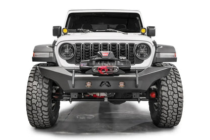 Fab Fours Premium front Lifestyle bumper on a white Jeep Wrangler JL, straight-on front view, showing the full-width bumper, winch with red hook and integrated round lights