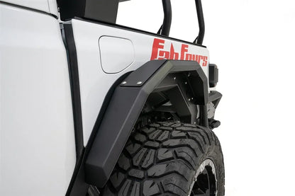 Close-up of Fab Fours rear fender flare on the driver side of a white Jeep Gladiator near the fuel door, with red Fab Fours graphics