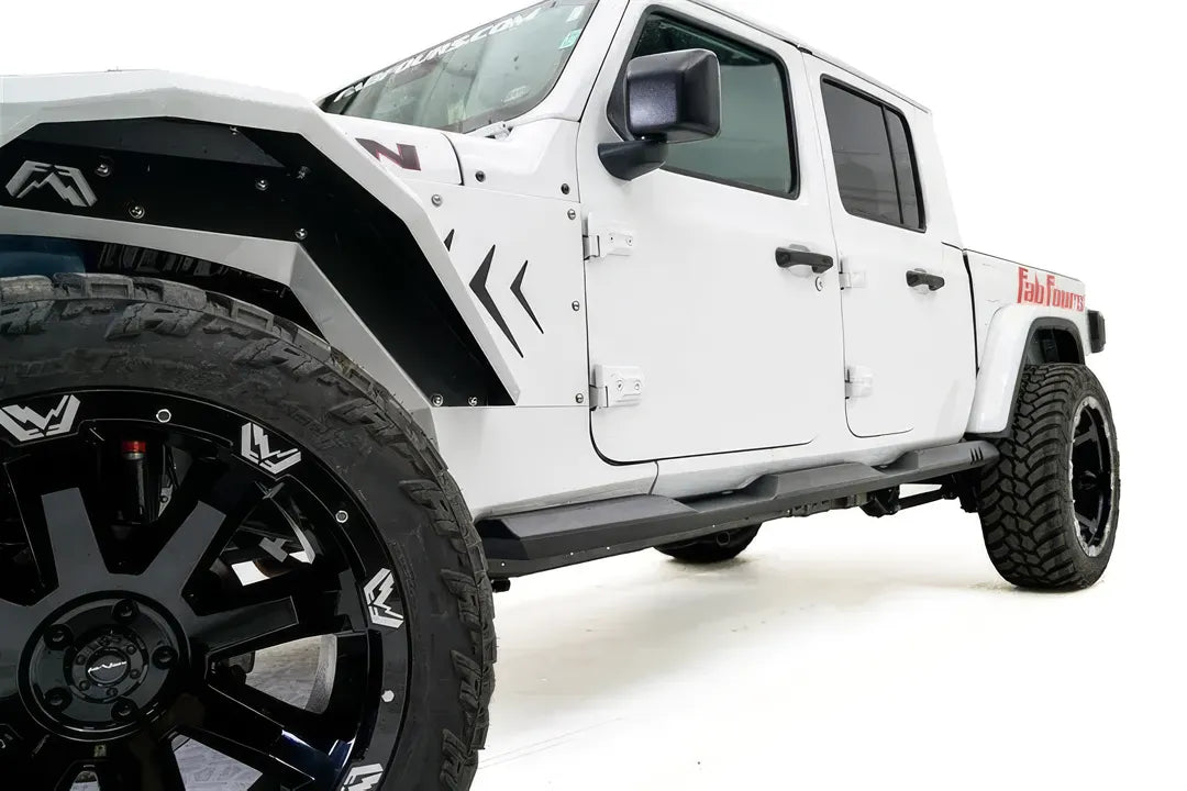 Fab Fours rock slider on a white Jeep Gladiator, front driver-side view