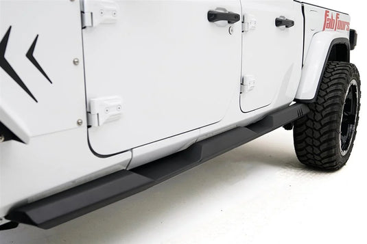 Fab Fours rock slider on a white Jeep Gladiator, low driver-side view, showing the matte black slider with step platforms beneath both doors